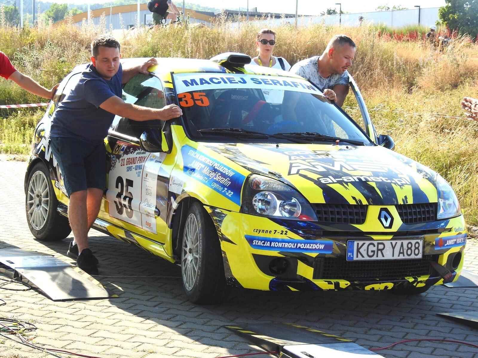 Maciej Serafin wraz z pomocnikiem wpycha samochód na lawetę