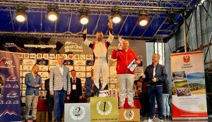 Kierowca wyścigowy Maciej Serafin na podium z pucharem w ręku