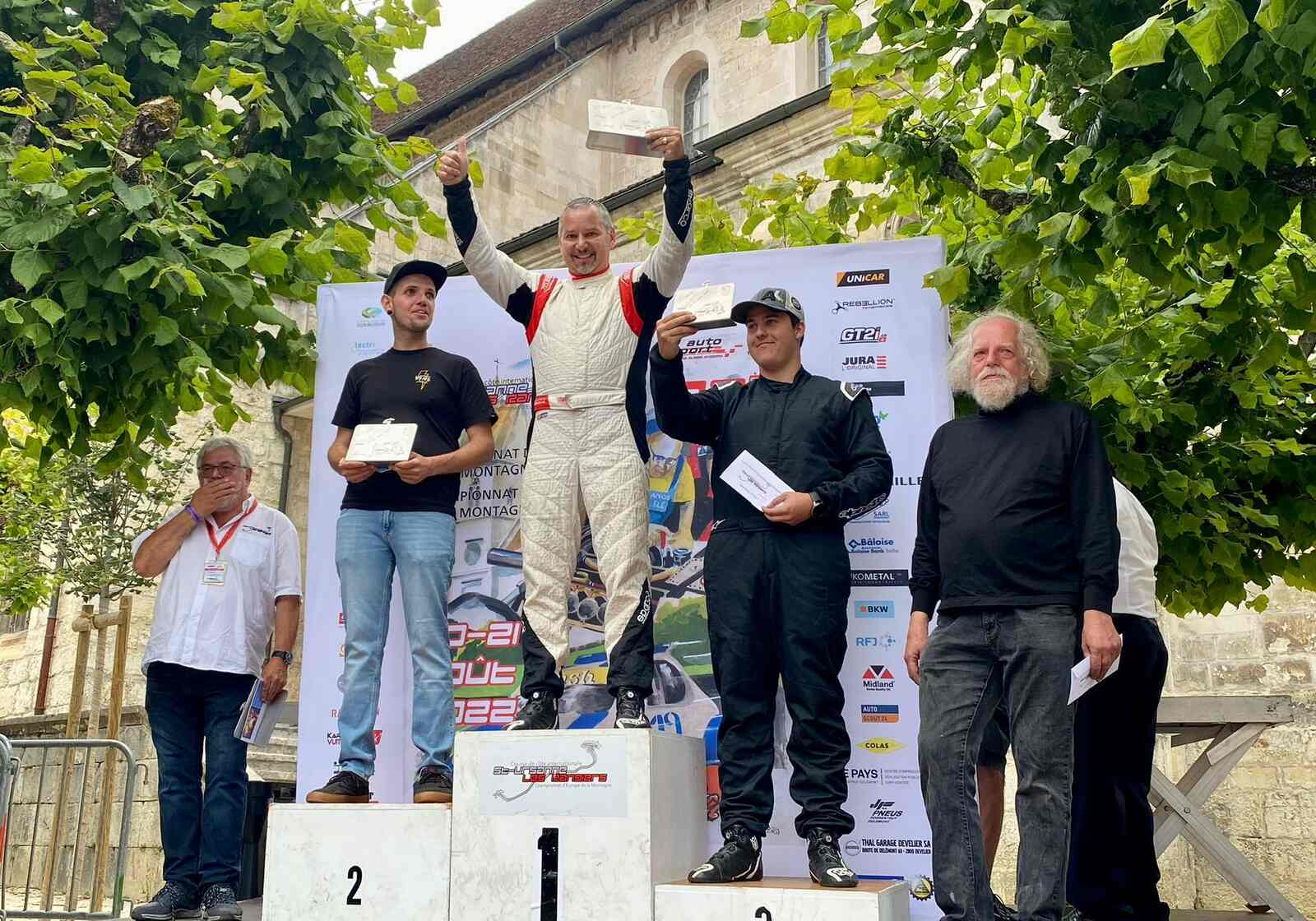 Kierowca wyścigowy Maciej Serafin na podium z pucharem w ręku