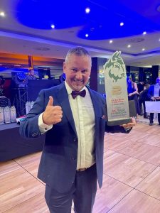 Maciej Serafin pozuje do zdjęcia z nagrodą