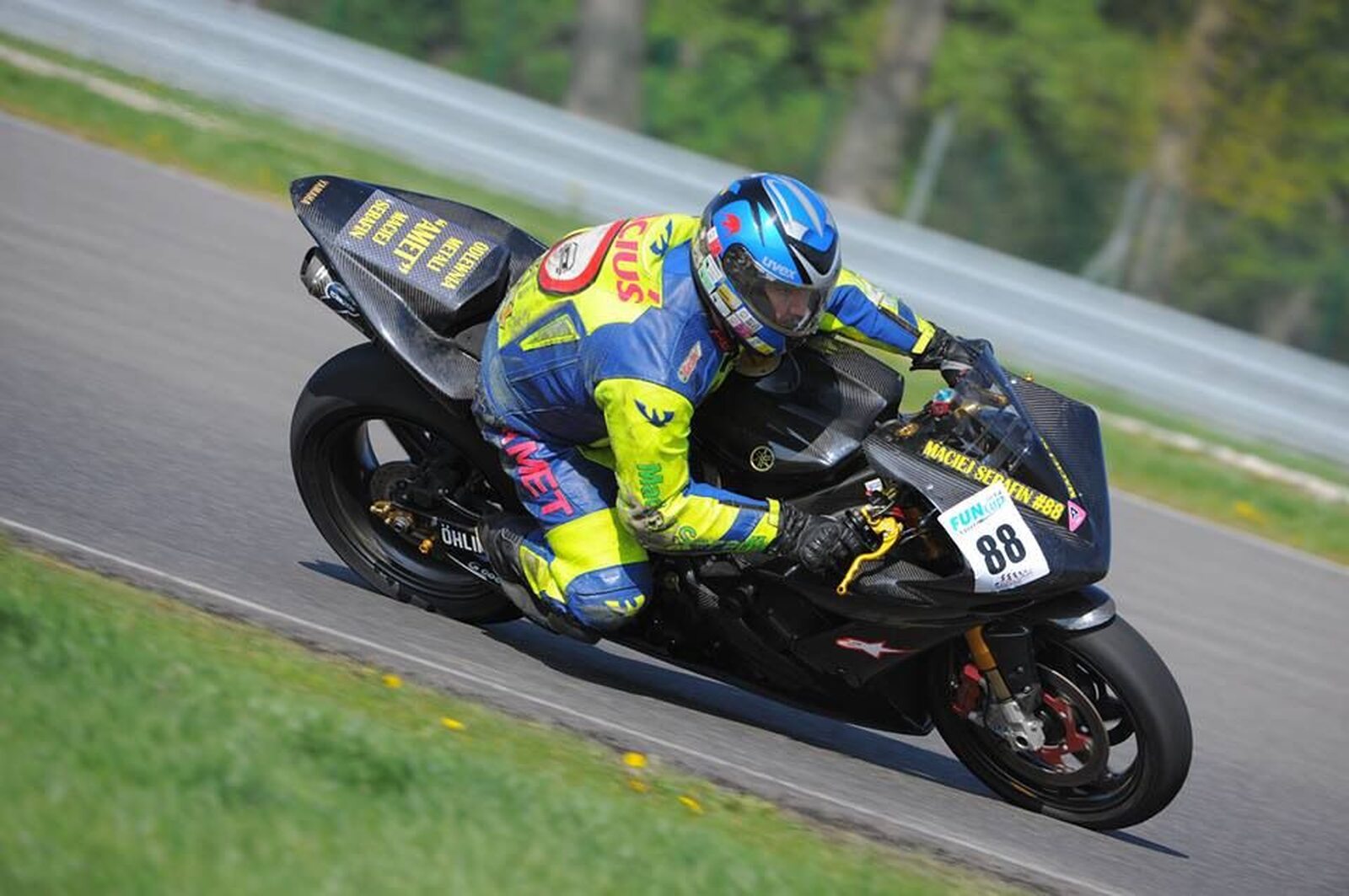 Motocyklista podczas wyścigu wchodzący w zakręt.
